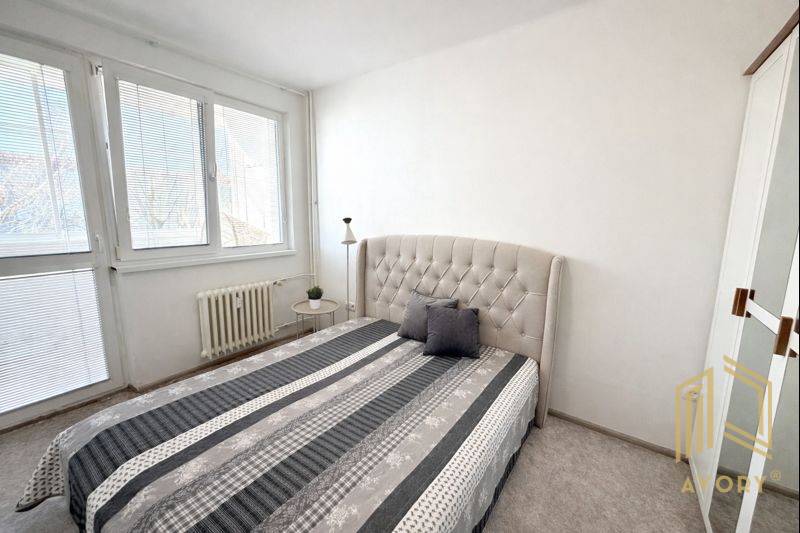  NA PREDAJ 2 -IZB BYT s LOGGIOU, KALINČIAKOVA UL. SENICA - Spálňa v 2-izbovom byte so svetlou posteľou a pruhovanou prikrývkou.