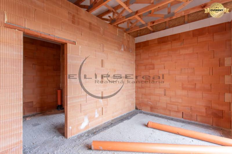 NA PREDAJ NOVOSTAVBA moderný 4-izbový rodinný dom v Malých Levároch - Hrubá stavba rodinného domu s tehlovými stenami a drevenými trámami.