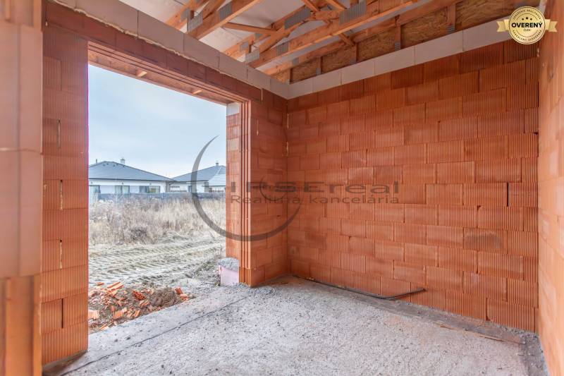 NA PREDAJ NOVOSTAVBA moderný 4-izbový rodinný dom v Malých Levároch - Nedokončená stena z tehál v interiéri Rodinného domu s výhľadom na okolie.
