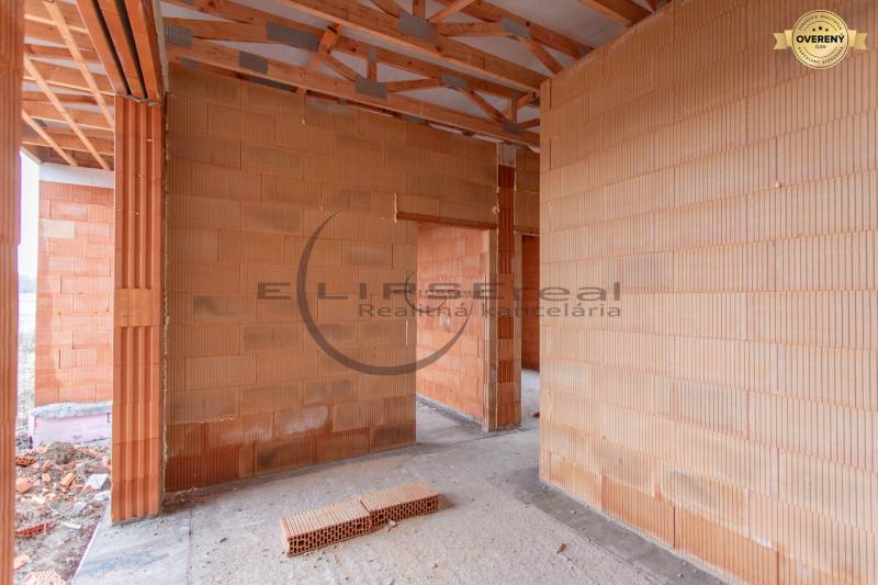 NA PREDAJ NOVOSTAVBA moderný 4-izbový rodinný dom v Malých Levároch - Interiér rodinného domu s neomietnutými tehlovými stenami a odhaleným dreveným stropom.