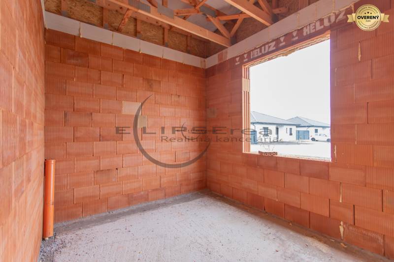 NA PREDAJ NOVOSTAVBA moderný 4-izbový rodinný dom v Malých Levároch - Stavba miestnosti v rodinnom dome s tehlovými stenami a betónovou podlahou.