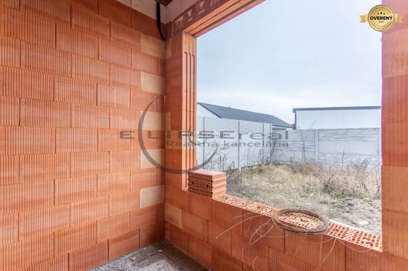 NA PREDAJ NOVOSTAVBA moderný 4-izbový rodinný dom v Malých Levároch - Nedokončená časť rodinného domu s tehlovým múrom, pohľad na záhradu v Malých Levároch.