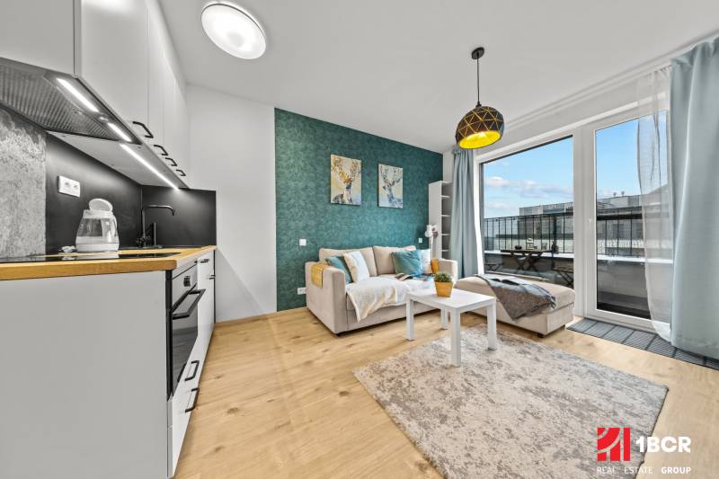 ZARIADENÝ 1-IZBOVÝ BYT, SLNEČNICE – IDEÁLNA INVESTÍCIA AJ BÝVANIE - Kuchyňa a obývačka s podlahou s dreveným dekorom v 1-izbovom byte.