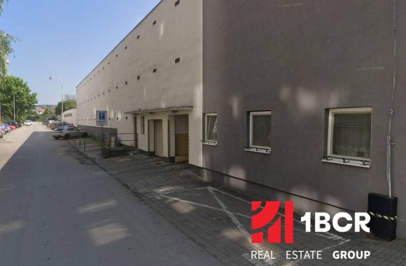 GARÁŽ V GARÁŽOVOM DOME NA SÍDLISKU SEVER, PEZINOK - L. NOVOMESKÉHO - Garáže na ulici Laca Novomeského v Pezinku s radom zaparkovaných áut.