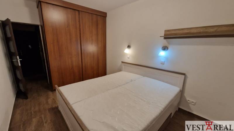 Na prenájom zariadený 3 izbový byt s balkónom Galanta- Mierová - Spálňa v 3-izbovom byte s posteľou, skriňou a podlahou s dreveným dekorom.