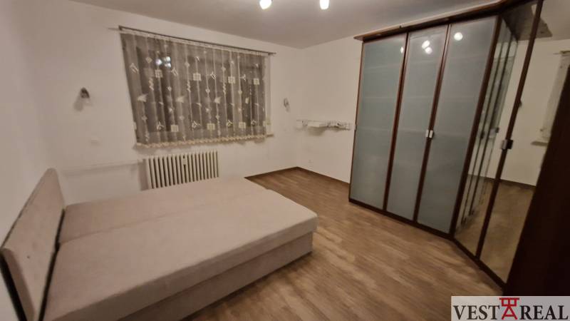 Na prenájom zariadený 3 izbový byt s balkónom Galanta- Mierová - Spálňa v 3-izbovom byte s posteľou, skriňou a podlahou s dreveným dekorom.