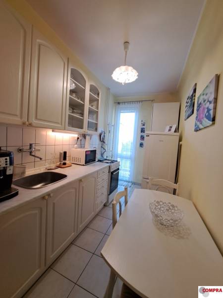 Pekný 2 izbový byt na Jadrovej ul. - Kuchyňa v 2-izbovom byte s bielym nábytkom a jedálenským stolom.