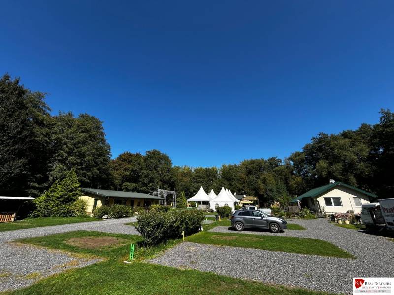 Zabehnutý multifunkčný rekreačný areál (kemp) Kuchyňa na predaj - Rekreačné pozemky v Kuchyni s parkoviskom, altánkom a okolitou zeleňou.