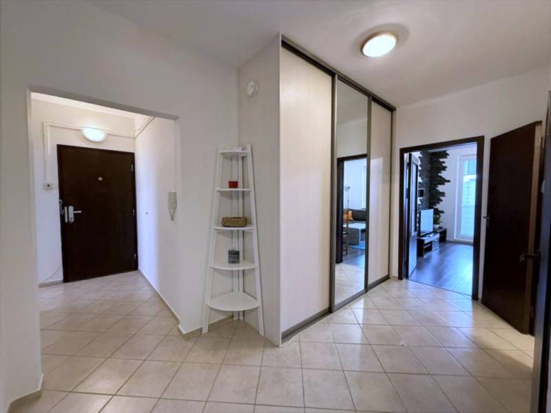 Útulný byt s loggiou a klimatizáciou, Rovniankova.Províziu neplatíte - Vstupná chodba s dlažbou, zrkadlovými dverami a policovým regálom v 3-izbovom byte.