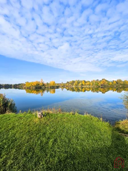 KH-1018, PREDAJ Pozemok pri jazere 887 m², garáž, altánok - Jazero s odrazom oblohy, obklopené zeleňou a jesennými stromami pri Čani.