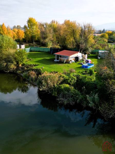 KH-1018, PREDAJ Pozemok pri jazere 887 m², garáž, altánok - Pokojná chatka pri rieke obklopená zeleňou a stromami v okolí Čane, výstavba domov.
