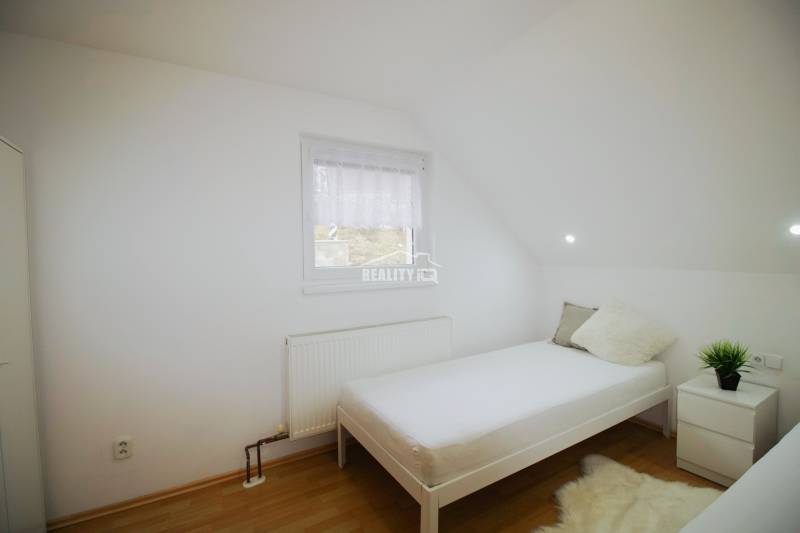 EXKLUZÍVNE / RODINNÝ DOM NA PREDAJ V OBCI SÚĽOV - Spálňa v rodinnom dome s posteľou, kobercovým kobercom a podlahou s dreveným dekorom.