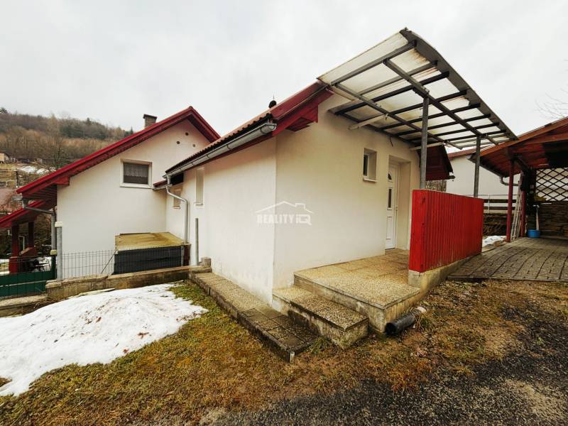 EXKLUZÍVNE / RODINNÝ DOM NA PREDAJ V OBCI SÚĽOV - Rodinný dom v Súľove-Hradnej s červenou strechou, zasneženou záhradou a prístreškom.