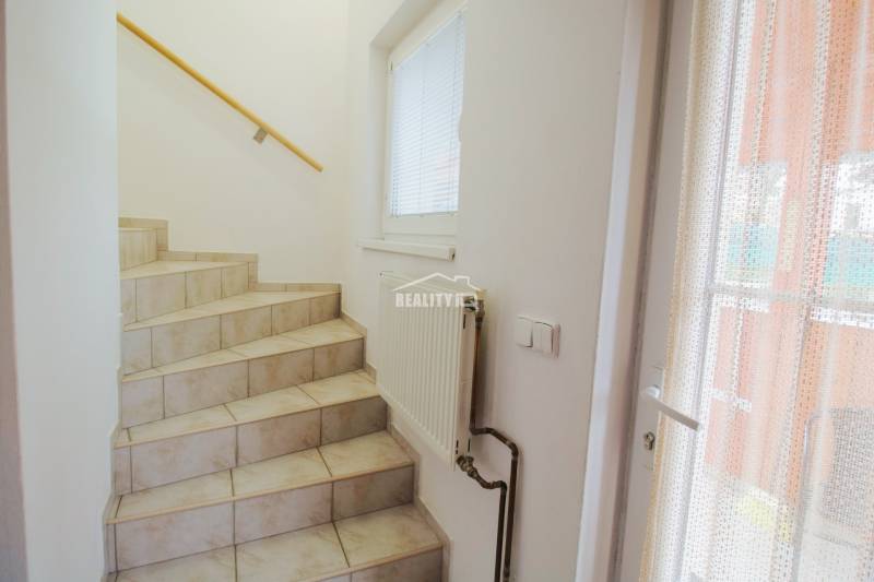 EXKLUZÍVNE / RODINNÝ DOM NA PREDAJ V OBCI SÚĽOV - Interiér schodiska v rodinnom dome s obkladanými schodmi a oknom.