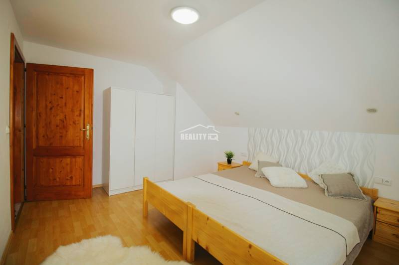 EXKLUZÍVNE / RODINNÝ DOM NA PREDAJ V OBCI SÚĽOV - Spálňa v rodinnom dome s drevenou posteľou a podlahou s dreveným dekorom.