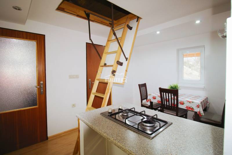 EXKLUZÍVNE / RODINNÝ DOM NA PREDAJ V OBCI SÚĽOV - Jedáleň s jedálenským stolom a plynovým sporákom v rodinnom dome.