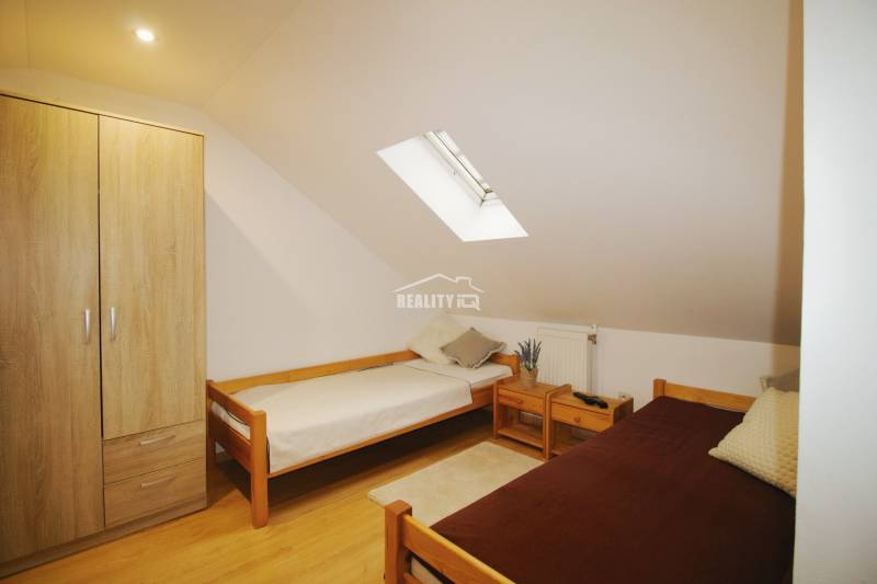 EXKLUZÍVNE / RODINNÝ DOM NA PREDAJ V OBCI SÚĽOV - Podkrovná izba v rodinnom dome s dvoma posteľami, drevenou skriňou a strešným oknom.