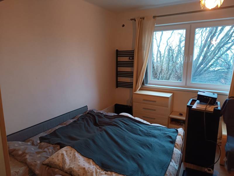 Na predaj rodinný dom Orovnica - Spálňa v rodinnom dome s posteľou, komodou a stromami viditeľnými z okna.