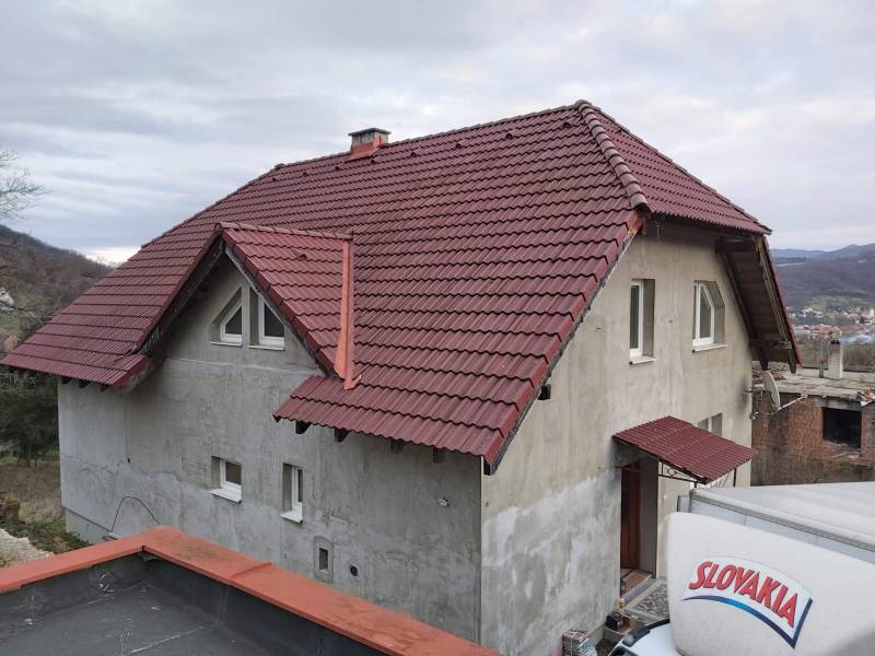 Na predaj rodinný dom Orovnica - Rodinný dom v Orovnici s nedokončenou fasádou a červenou škridlovou strechou.