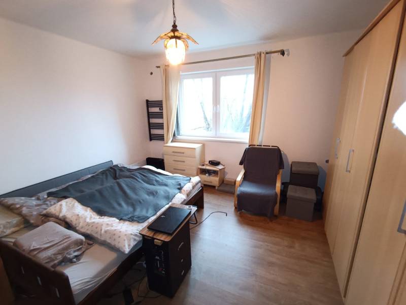 Na predaj rodinný dom Orovnica - Spálňa v Rodinnom dome s posteľou, skrine, kreslom a podlahou s dreveným dekorom.