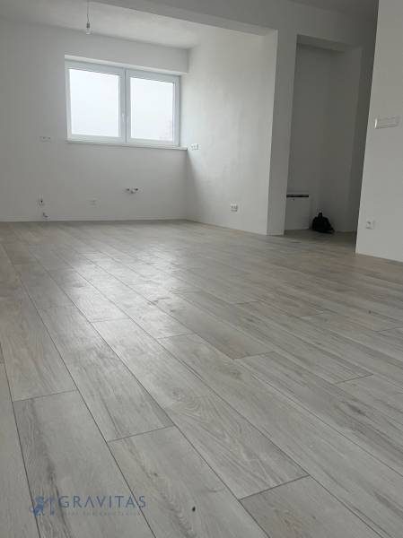 REZERVOVANÉ! Na predaj 2 izb. byt blízko centra, Chorvátsky Grob - Svetlá miestnosť v 2-izbovom byte s podlahou s dreveným dekorom a veľkým oknom.