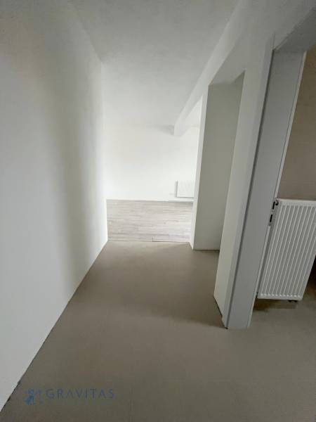 REZERVOVANÉ! Na predaj 2 izb. byt blízko centra, Chorvátsky Grob - Chodba s bielymi stenami a podlahou s dreveným dekorom v 2-izbovom byte.