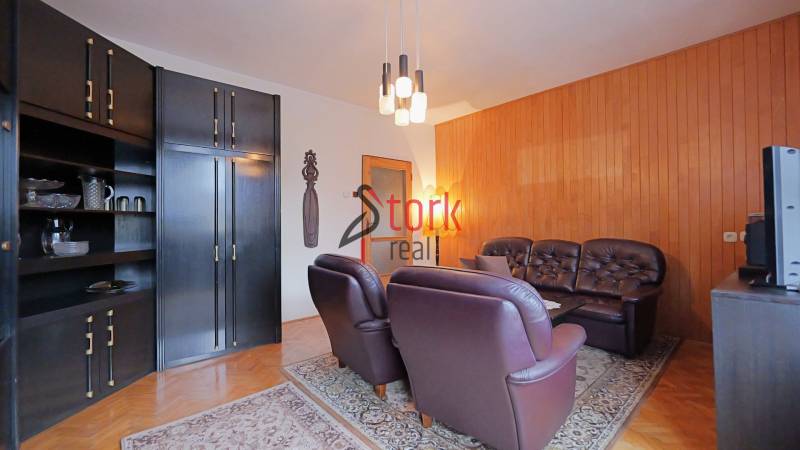 Nová ponuka - Rodinný dom v CENTRE MESTA Rajecké Teplice - Obývacia izba v rodinnom dome s koženou sedačkou a dreveným dekorom na stene.