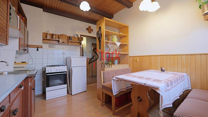 Nová ponuka - Rodinný dom v CENTRE MESTA Rajecké Teplice - Kuchyňa v rodinnom dome s dreveným obkladom, plynovým sporákom a rohovou lavicou.