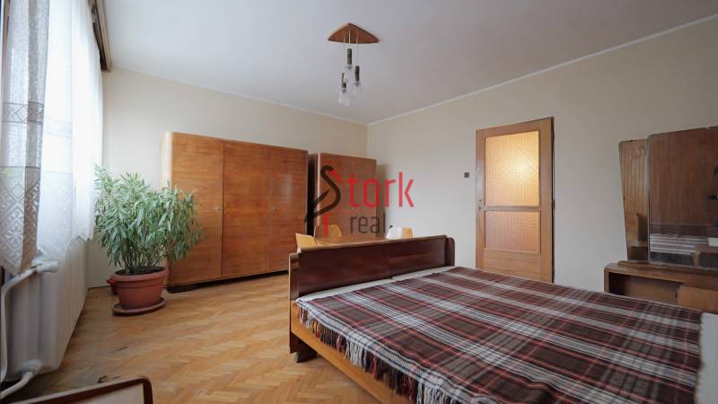 Nová ponuka - Rodinný dom v CENTRE MESTA Rajecké Teplice - Spálňa v rodinnom dome s dreveným dekorom, masívnym nábytkom a kvetmi v kvetináči.