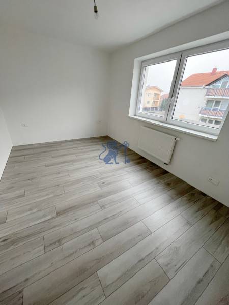 Na predaj 2 izb. byt s balkónom blízko centra, Chorvátsky Grob - Prázdna izba v 2-izbovom byte, s podlahou s dreveným dekorom a veľkým oknom.