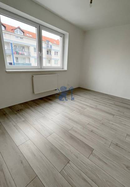 Na predaj 2 izb. byt s balkónom blízko centra, Chorvátsky Grob - Izba s podlahou s dreveným dekorom a veľkým oknom v 2-izbovom byte.