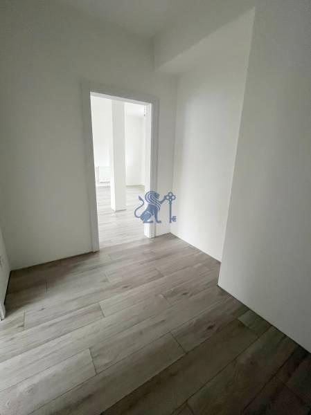 Na predaj 2 izb. byt s balkónom blízko centra, Chorvátsky Grob - Priestor v 2-izbovom byte s bielymi stenami a podlahou s dreveným dekorom.