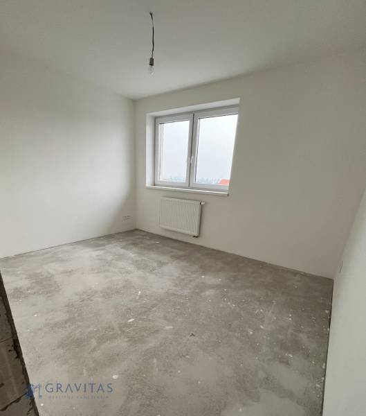 Na predaj 3 izb. byt s balkónom blízko centra, Chorvátsky Grob - Nezariadená izba so sivo-betónovou podlahou a bielymi stenami v 3-izbovom byte.