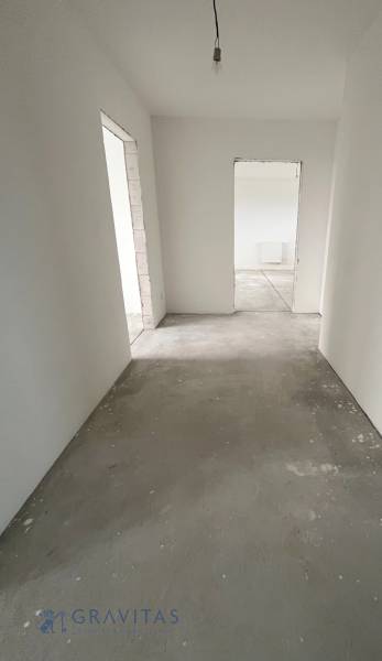 Na predaj 3 izb. byt s balkónom blízko centra, Chorvátsky Grob - Chodba v 3-izbovom byte s betónovou podlahou a bielymi stenami.