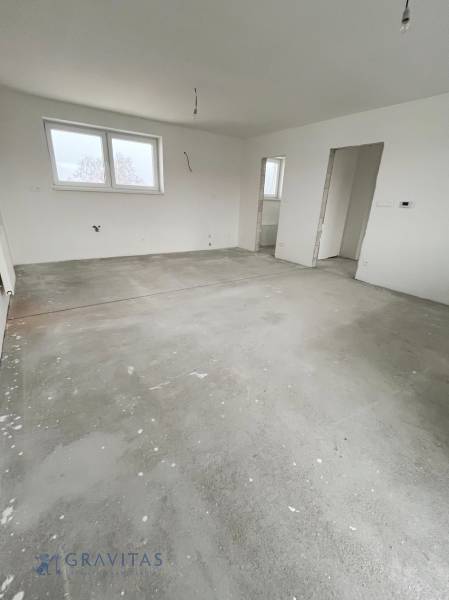 Na predaj 3 izb. byt s balkónom blízko centra, Chorvátsky Grob - Prázdna miestnosť v 3-izbovom byte bez podlahovej krytiny a s bielymi stenami.