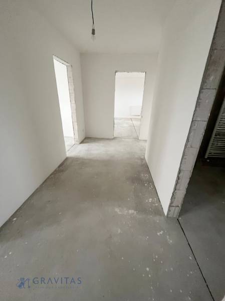 Na predaj 3 izb. byt s balkónom blízko centra, Chorvátsky Grob - Prázdna miestnosť s bielymi stenami v 3-izbovom byte, dvere vedú do ďalších izieb.