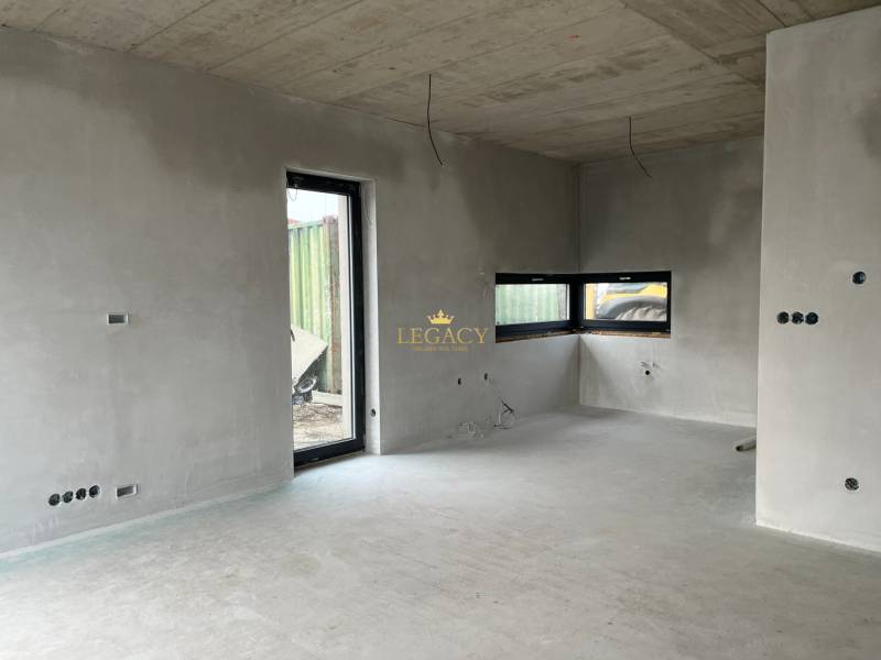 5-izbový rodinný dom – holodom s prémiovým štandardom, Chorvátsky Grob - Interiér rodinného domu s betónovými stenami a veľkými oknami, vidno neúplnú elektrickú inštaláciu.