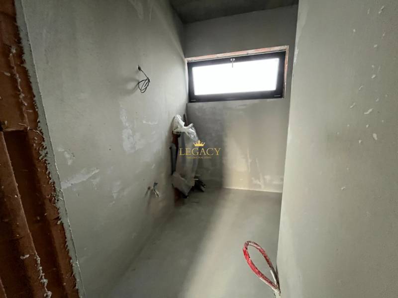 5-izbový rodinný dom – holodom s prémiovým štandardom, Chorvátsky Grob - Nedokončená miestnosť v rodinnom dome s oknom a odhaleným potrubím.