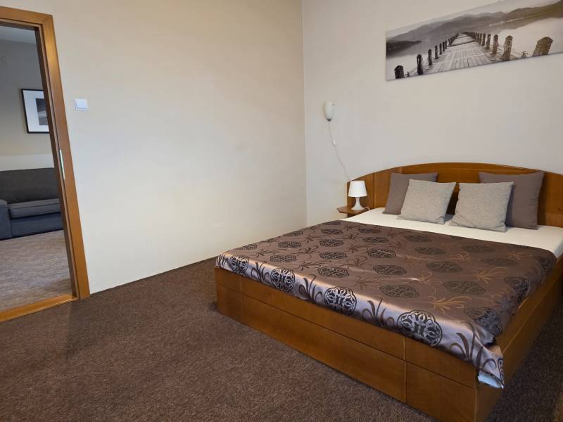 PRENÁJOM - Priestranný 3 izbový byt - Nitra, Centrum - Spálňa v 3-izbovom byte so štýlovou posteľou, žiarivými obliečkami a príjemným kobercom.