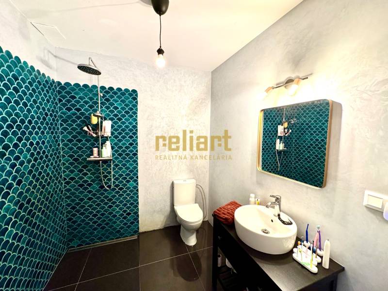 Moderný radový rodinný dom v Novej Dedinke, projekt “Lastovičky” - Kúpeľňa s tmavou podlahou a modrými obkladmi v rodinnom dome.