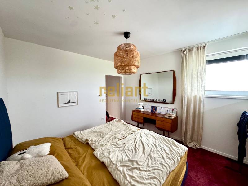 Moderný radový rodinný dom v Novej Dedinke, projekt “Lastovičky” - Spálňa v rodinnom dome s posteľou, zrkadlom a červeným kobercom na podlahe.