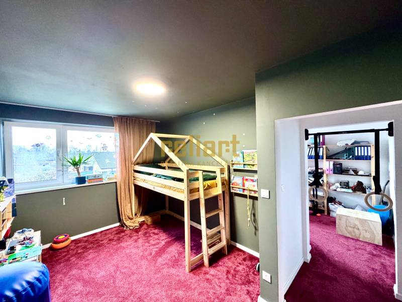 Moderný radový rodinný dom v Novej Dedinke, projekt “Lastovičky” - Detská izba v rodinnom dome s drevenou posteľou a bordovým kobercom.