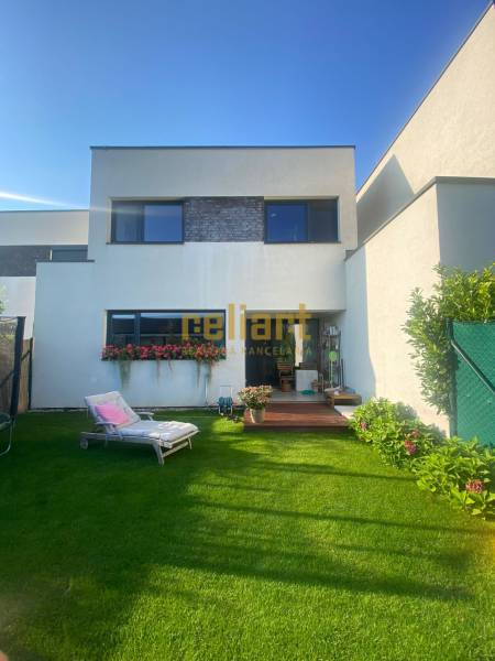 Moderný radový rodinný dom v Novej Dedinke, projekt “Lastovičky” - Rodinný dom na Radovej ulici v Novej Dedinke má udržiavanú záhradu s ležadlom.