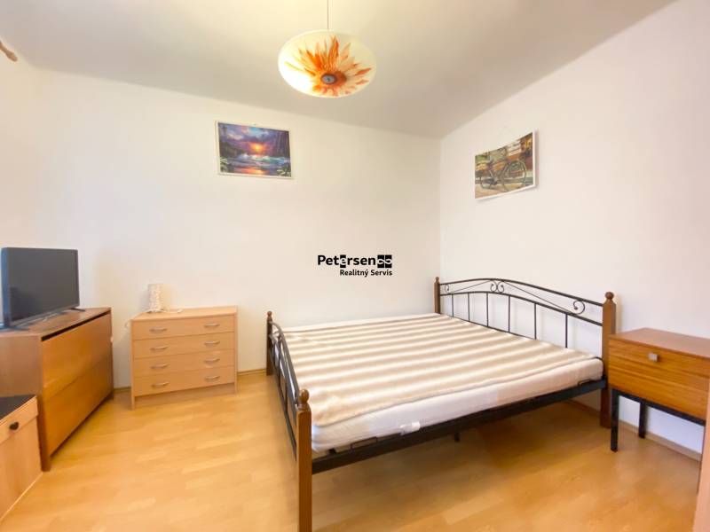 NA PRENÁJOM 2-IZBOVÝ BYT, NÁRODNÁ TRIEDA - Spálňa v 2-izbovom byte s nábytkom a podlahou s dreveným dekorom.