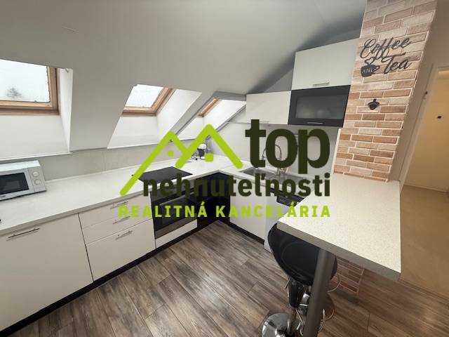 TOPOĽČANY Priestranný 1-izbový byt na prenájom 60 m2 - Kuchyňa v 1-izbovom byte s podlahou s dreveným dekorom a strešnými oknami.