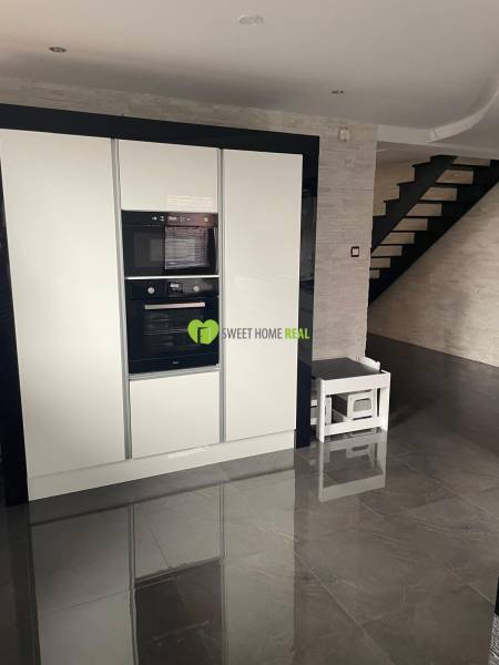 Moderný zariadený rodinný dom na prenájom 120m2 s terasou Košice Barca - Kuchyňa v rodinnom dome s lesklou čiernou podlahou a bielymi spotrebičmi.