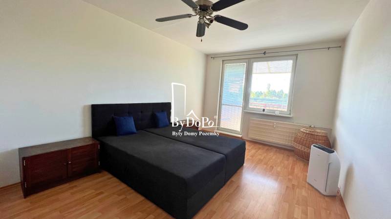 3-izbový byt na prenájom, 87 m2, Beethovenova ul. Nitra - Spálňa v 3-izbovom byte s lôžkom a ventilátorom, podlaha s dreveným dekorom.