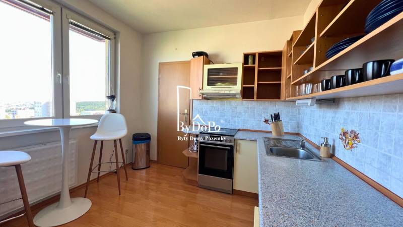 3-izbový byt na prenájom, 87 m2, Beethovenova ul. Nitra - Kuchyňa v 3-izbovom byte s podlahou s dreveným dekorom a jedálenským stolom.