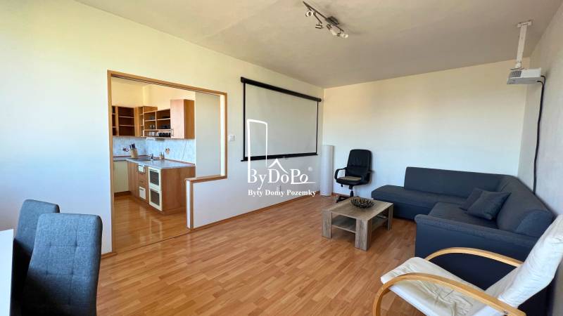 3-izbový byt na prenájom, 87 m2, Beethovenova ul. Nitra - Obývačka v 3-izbovom byte s podlahou s dreveným dekorom a kuchyňou.