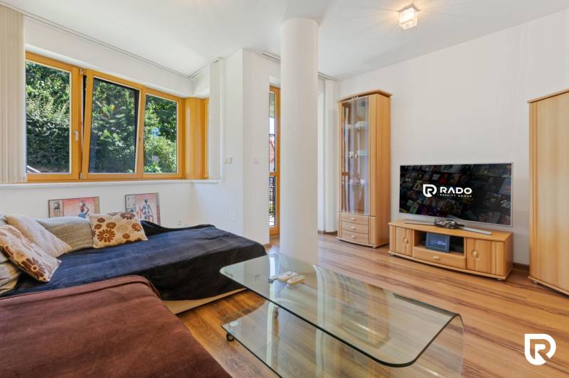 Staré Mesto | 5i byt 175 m² + 4 balkóny + možnosť 2× parking - Obývačka s gaučom, skleneným stolom, televízorom a podlahou s dreveným dekorom v 5 a viac izbovom byte.